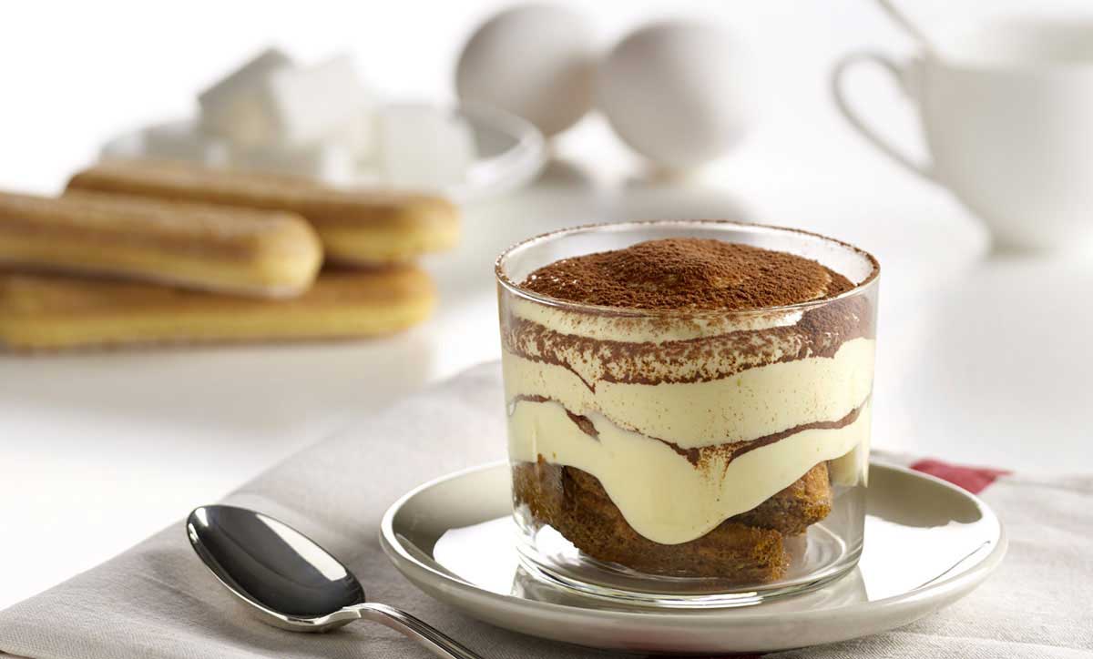 A finished tiramisu dessert served with cocoa topping